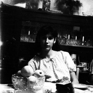 Black and white image of a woman at a table.