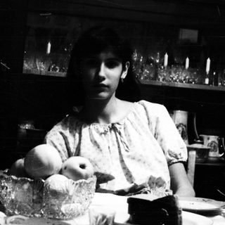 Black and white image of a woman at a table.