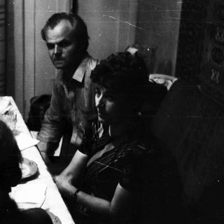 Man and two women seated at a table indoors.