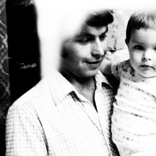 Man holds young child in a black and white photo.