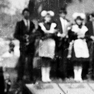 Group poses near a statue, likely for a commemorative event.