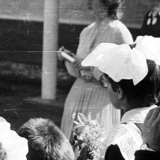 Black and white photo of people gathered outdoors.