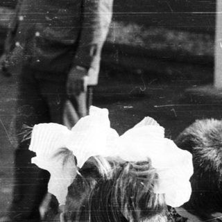 Black and white photo of people gathered outdoors.