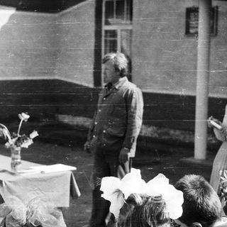 Black and white photo of people gathered outdoors.