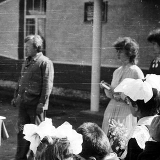 Black and white photo of people gathered outdoors.