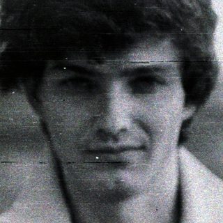Black and white portrait of a young man with short hair.