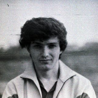 Black and white portrait of a young man with short hair.