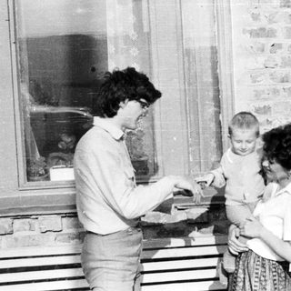 Black and white photo of people near a window.