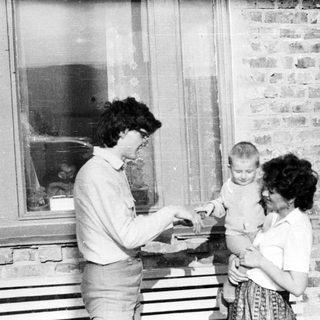 Black and white photo of people near a window.