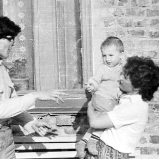 Black and white photo of a person holding a baby.