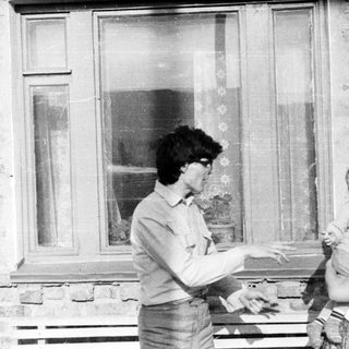Black and white photo of a person holding a baby.