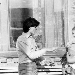 Black and white photo of a person holding a baby.