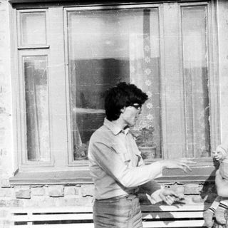 Black and white photo of a person holding a baby.