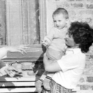 Black and white photo of a person holding a baby.