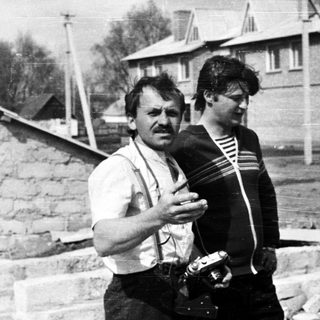 Man and boy near a brick wall under construction.
