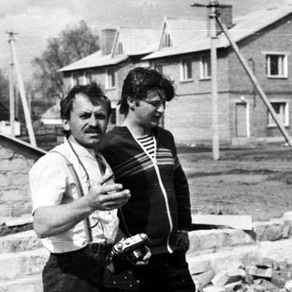Man and boy near a brick wall under construction.