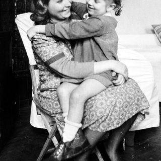 Woman and child embracing in a vintage, black and white photograph.