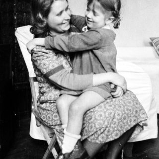 Woman and child embracing in a vintage, black and white photograph.