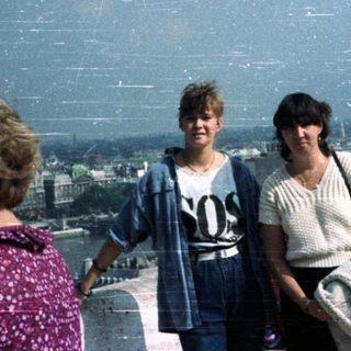 People view a cityscape from a tower platform.