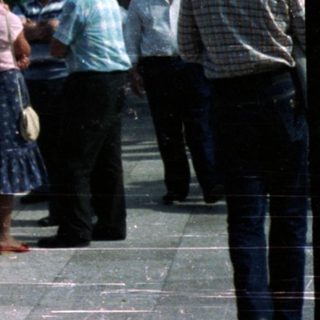 People view a cityscape from a tower platform.