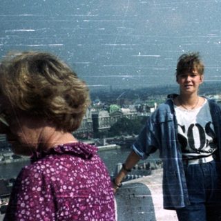 People view a cityscape from a tower platform.