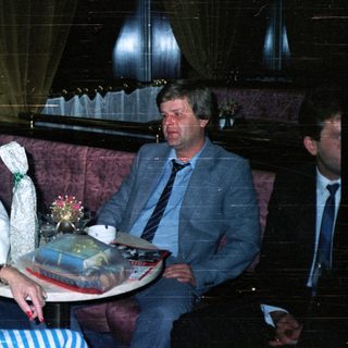 People seated in a room with gifts on a table.