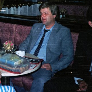 People seated in a room with gifts on a table.