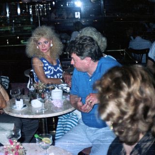 Group of people socializing at a table in a nightclub.
