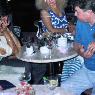 Group of people socializing at a table in a nightclub.