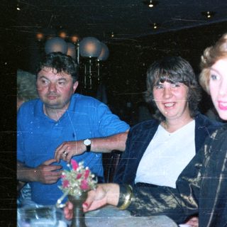 Three people are indoors, appearing to celebrate or socialize.