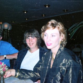 Three people are indoors, appearing to celebrate or socialize.
