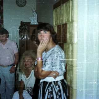 People in a dining room with a television.