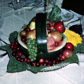 Elegant table setting with fruit display and fine china.
