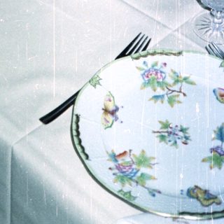 Elegant table setting with fruit display and fine china.