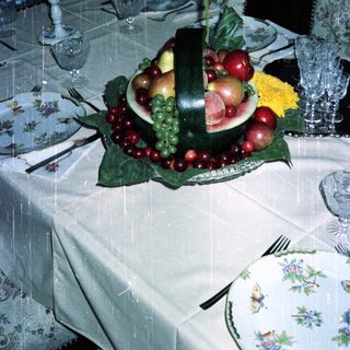 Elegant table setting with fruit display and fine china.