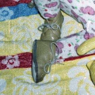 Baby in a crib with toys, looking upwards.
