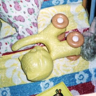Baby in a crib with toys, looking upwards.