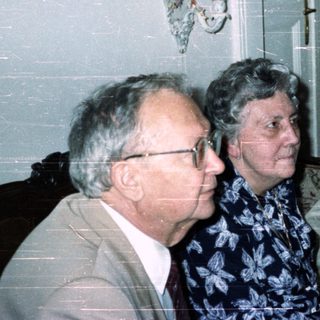 Three people seated in a room with antique furniture.