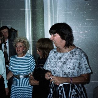 Group of people in 1980s attire posing indoors.