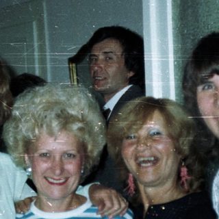 Group of people posing indoors, styled with 1980s fashion.