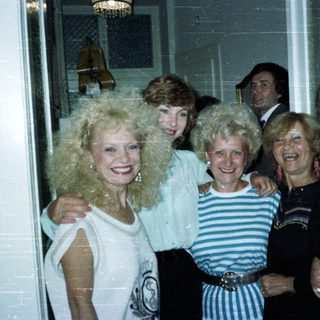 Group of people posing indoors, styled with 1980s fashion.