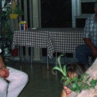 Group of people posing in a room with a fish tank.