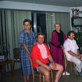 Group of people posing in a room with a fish tank.