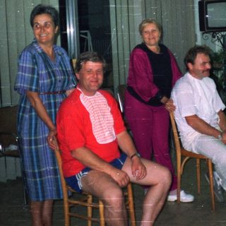 Group of people posing in a room with a fish tank.