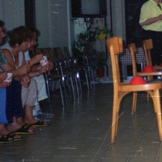 People gathered in a room, a woman serving drinks.