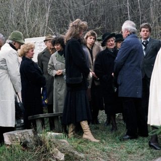 Group gathers at a gravesite, possibly for a memorial.