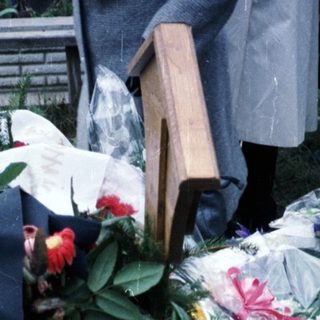 Floral tributes and wreaths at a gravesite or memorial.