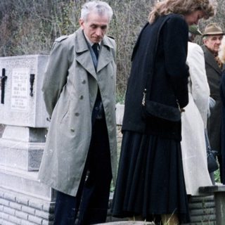Group of people standing near a monument in a park.