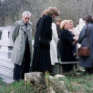 Group of people standing near a monument in a park.