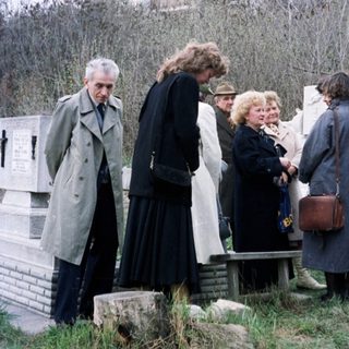 Group of people standing near a monument in a park.